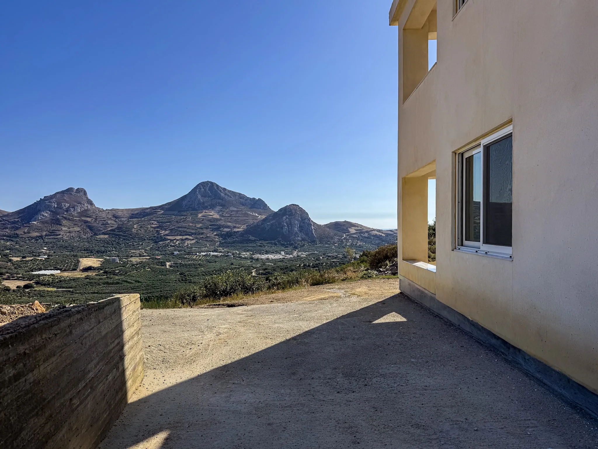 The rock peaks above the olive groves, seen from beside the houses